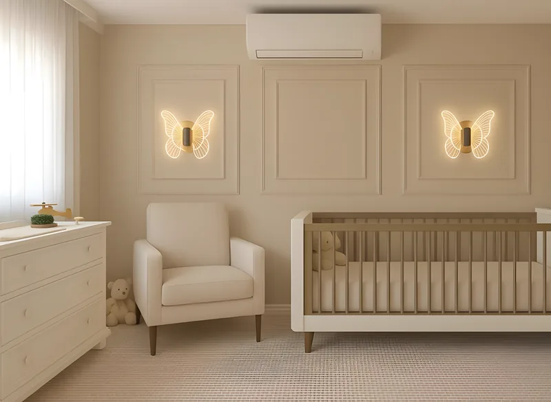 Dormitorio infantil en tonos neutros con cuna, sillón y apliques en forma de mariposa